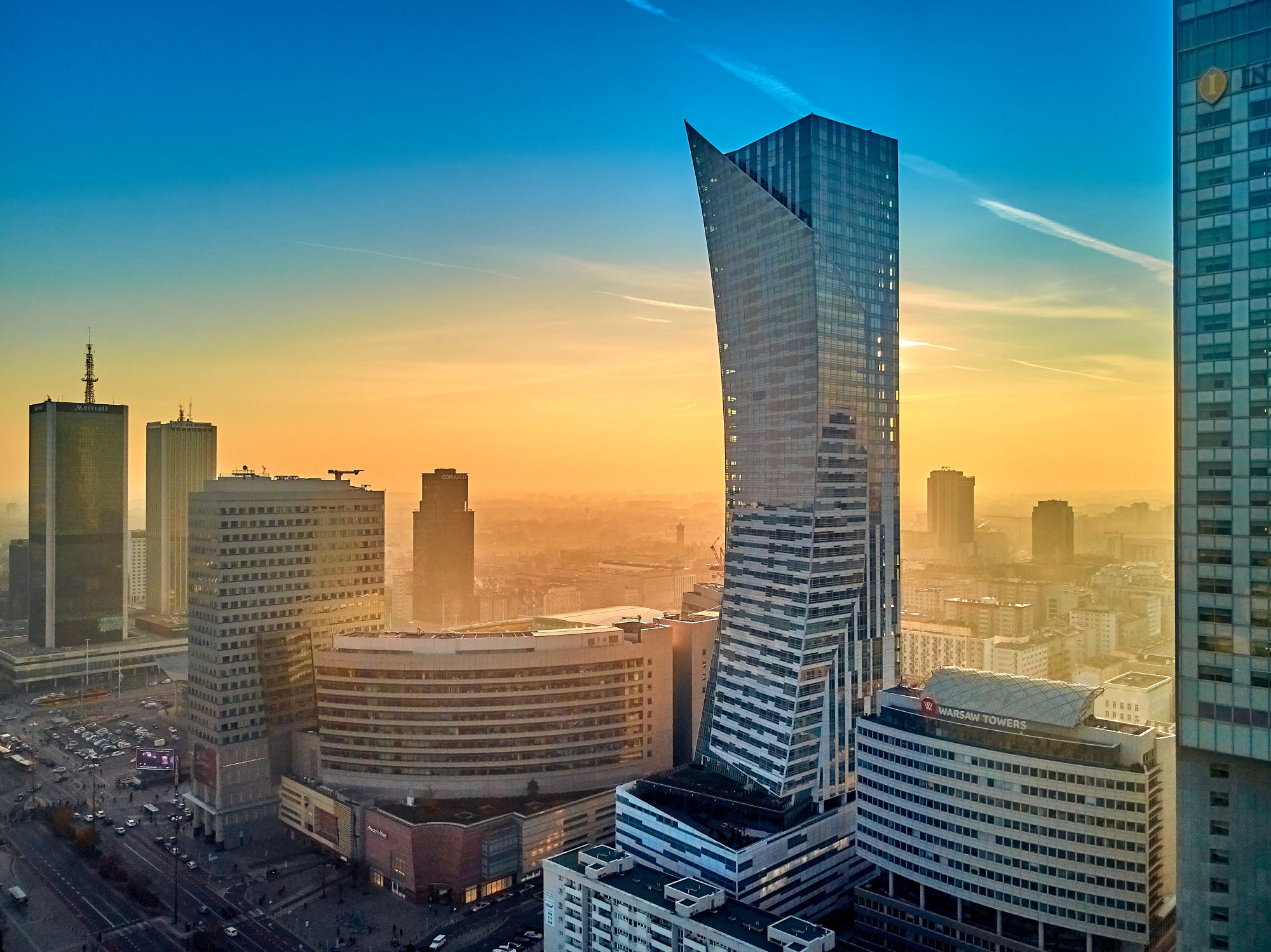 Luksusowy wieżowiec Złota 44 w Warszawie na tle zachodzącego słońca i panoramy miasta